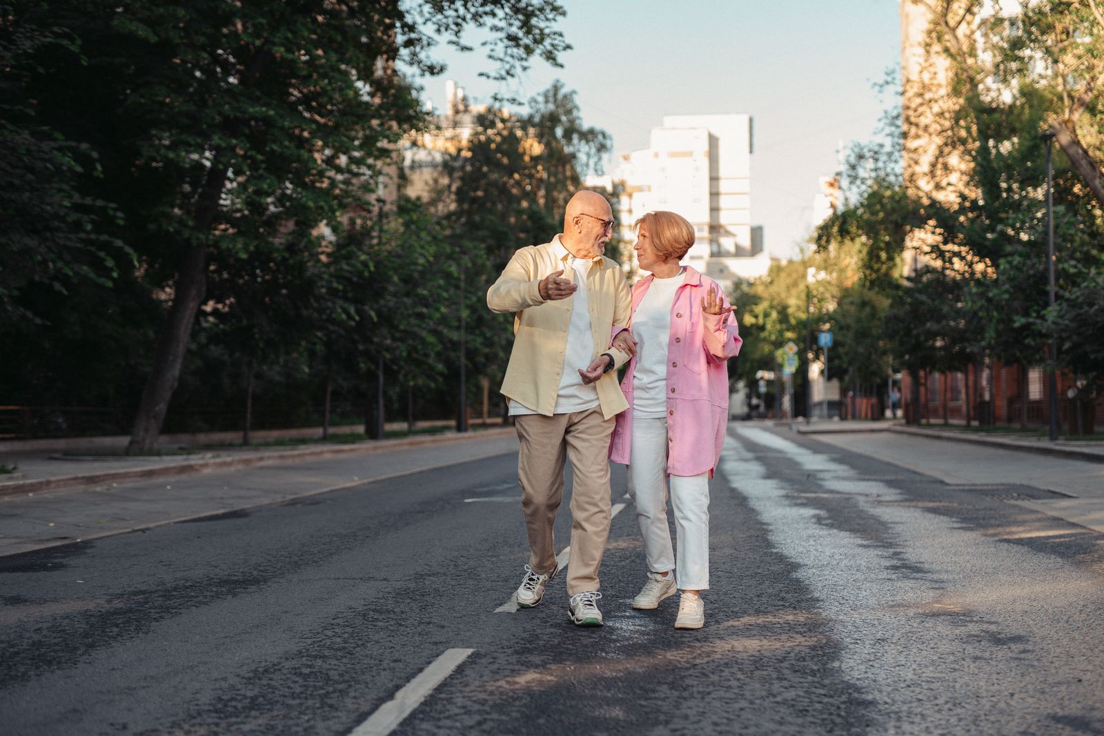 A happy elderly couple walking together on a sunny street
