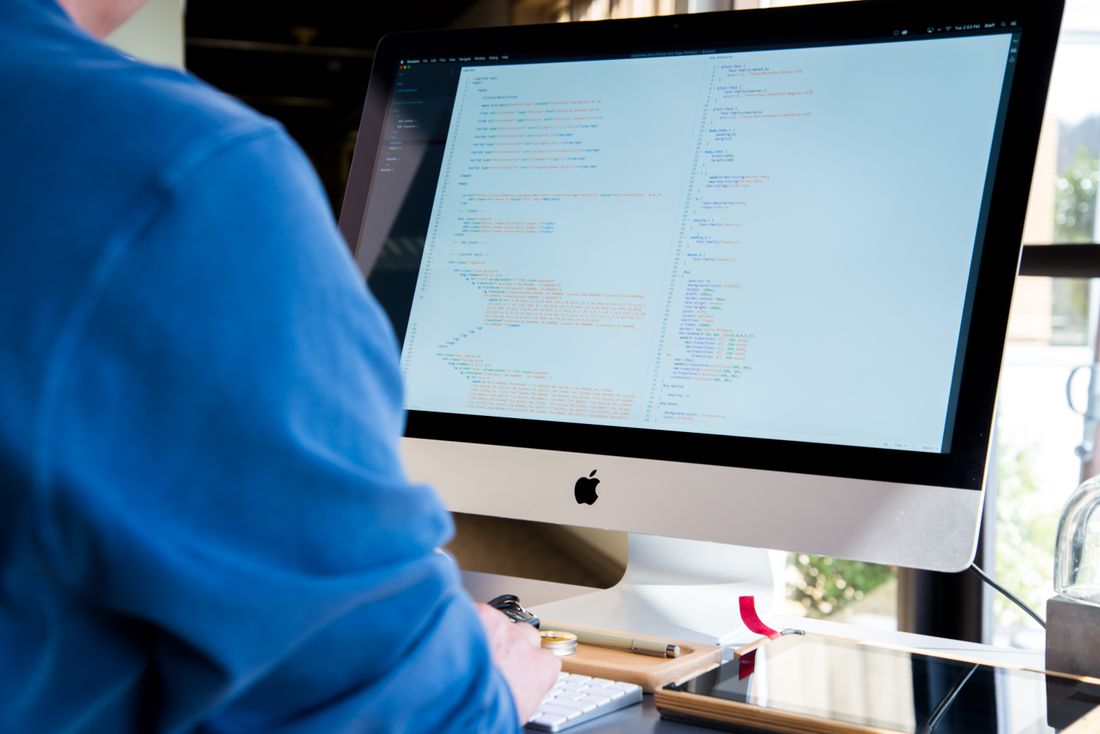 Entwickler programmiert am Bildschirm – individuelle Website statt Baukasten.