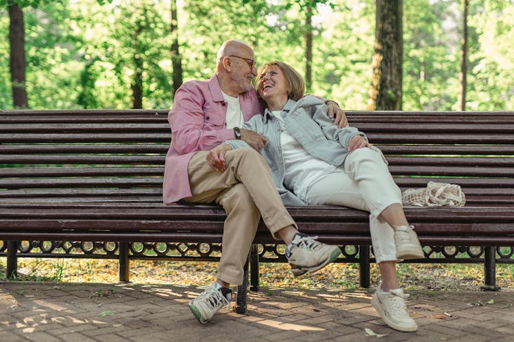 Elderly Couple Sitting On The Park Bench