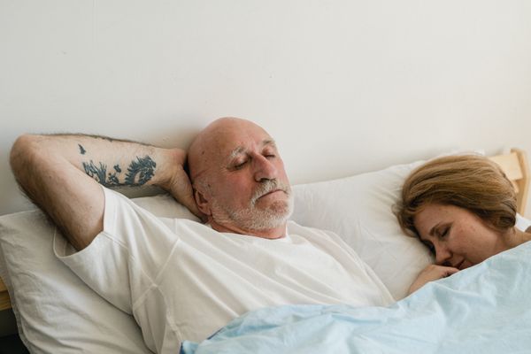 Older couple sleeping peacefully in bed