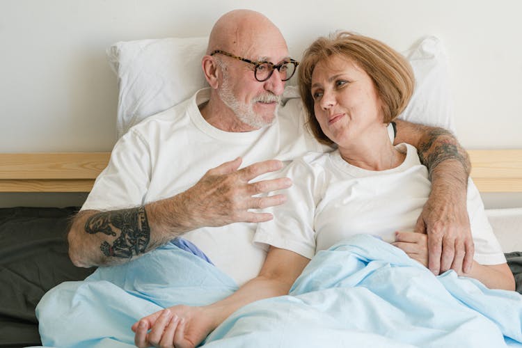 Elderly Couple Lying On Bed