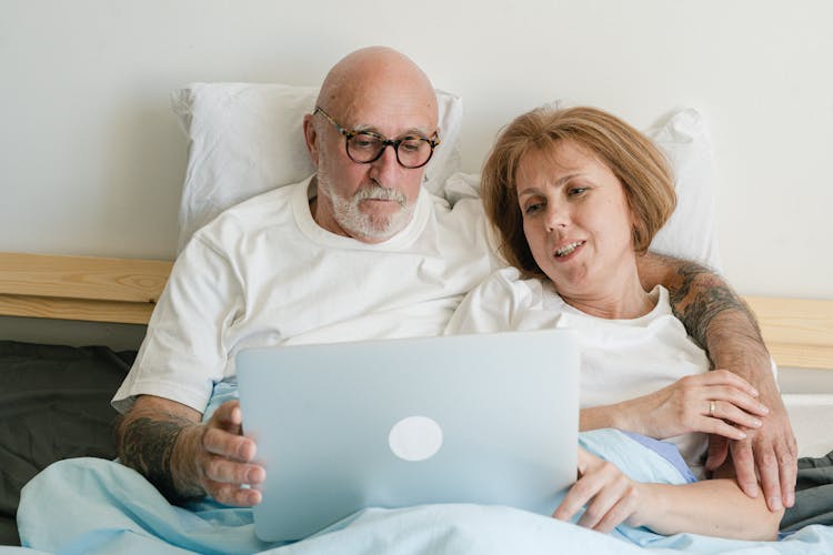 Elderly Couple Looking At The Screen Of A Laptop