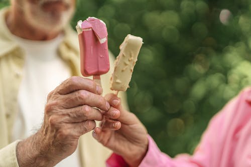 Close-Up Shot of an Elderly Couple Holding Ice Pops