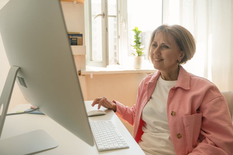 An Elderly Woman Using A Desktop Computer