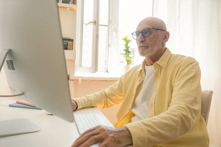 A Man Looking At A Desktop Monitor