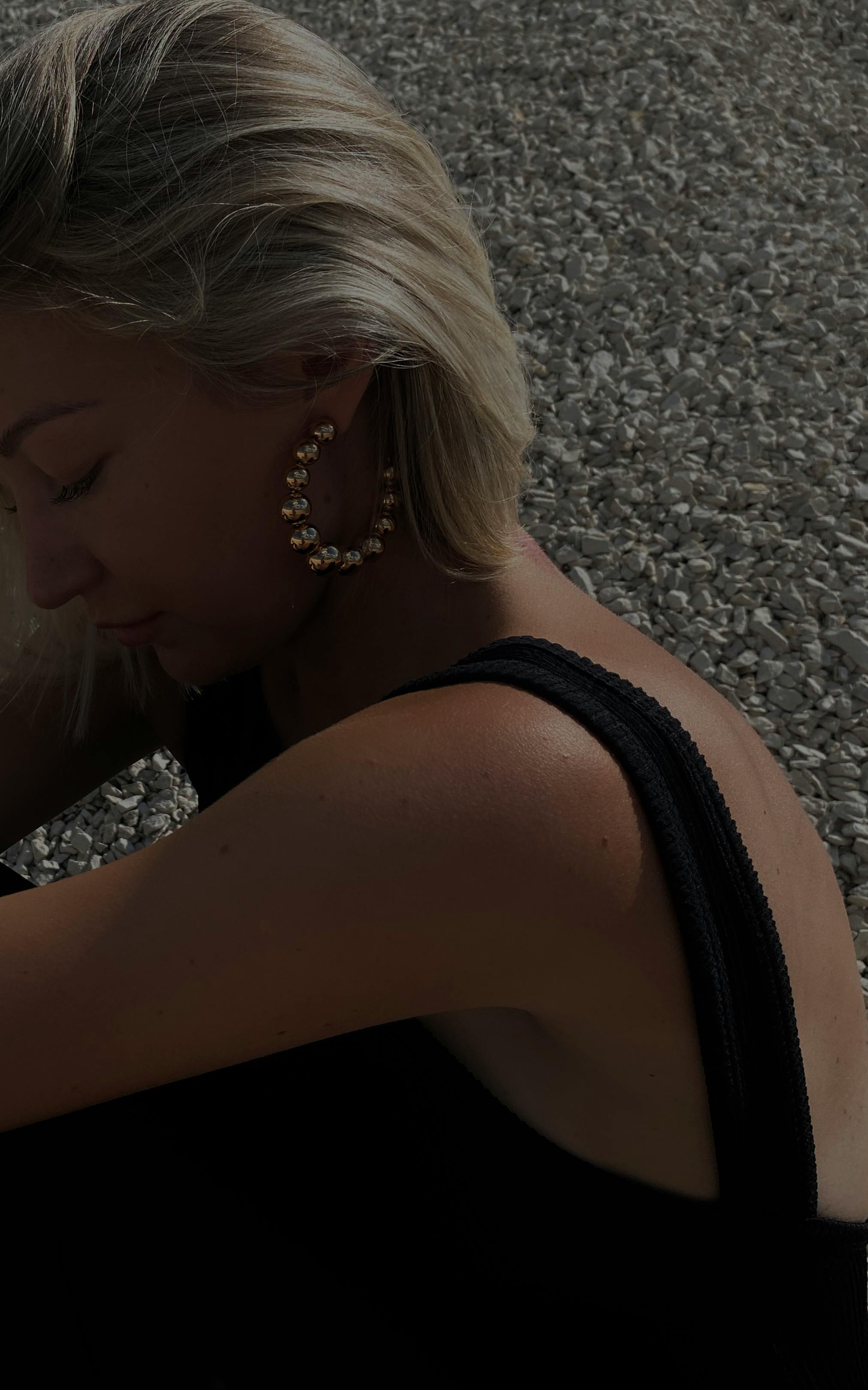 beautiful woman in black dress wearing earrings