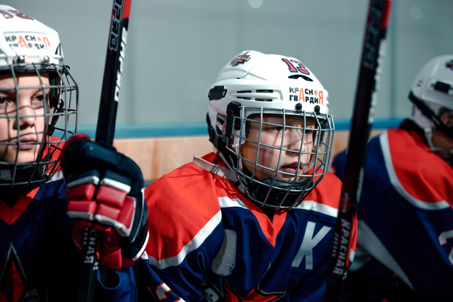 Close-up of young ice hockey players with sticks and helmets, ready for a game on the rink.