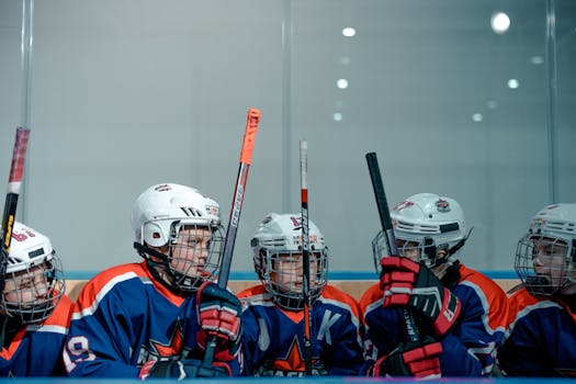 Young hockey players on the bench during a game, ready for action.