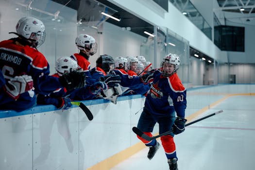 Ice hockey team players celebrating during a game in an indoor rink.