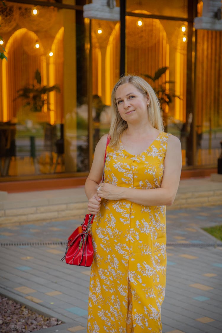 Woman In Yellow Sundress Standing On Street