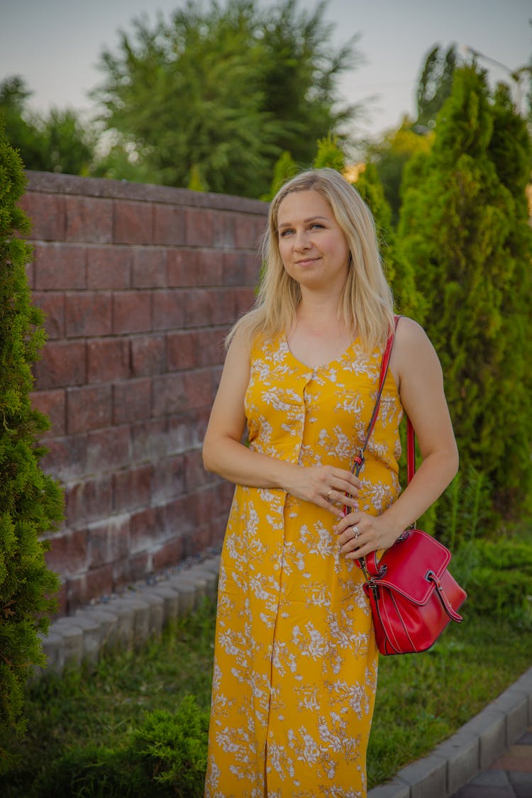 Woman In Yellow Sundress Standing In Park