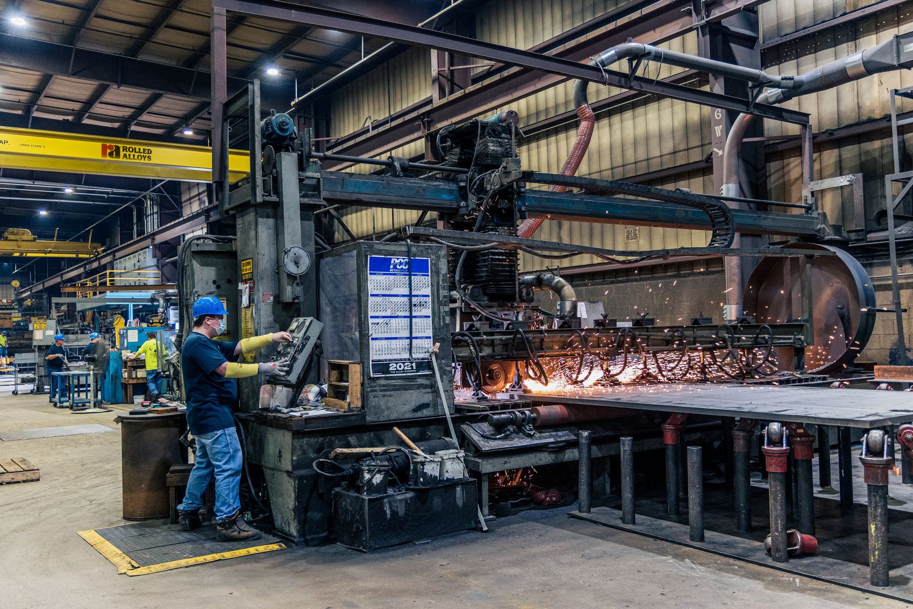 Ambiente industrial com operador e equipamento de fabricação metálica