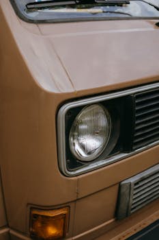 Detailed close-up of a vintage VW van headlight showcasing its iconic design.
