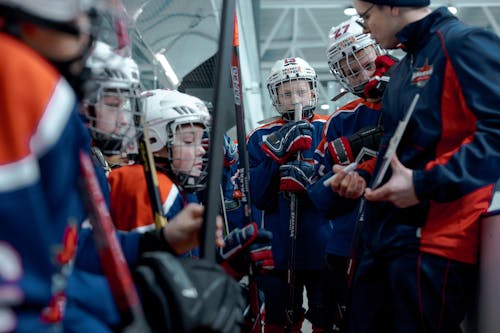 Group of People in Red and Blue Uniform Holding Sticks