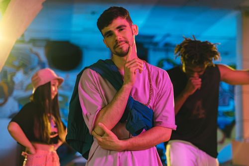 Free Trendy young adults in colorful streetwear with vibrant lighting. Stock Photo