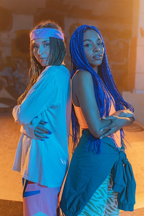 Young Women in Trendy Casual Clothes Standing Back to Back 