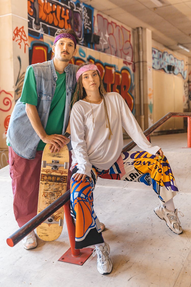 Couple In Colorful Clothes Relaxing In Skate Park