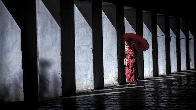 Buddhist Monk Boy Walking With An Umbrella 