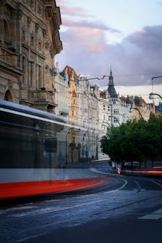 Captivating long exposure shot of a tram moving through historic streets in Prague at dusk.
