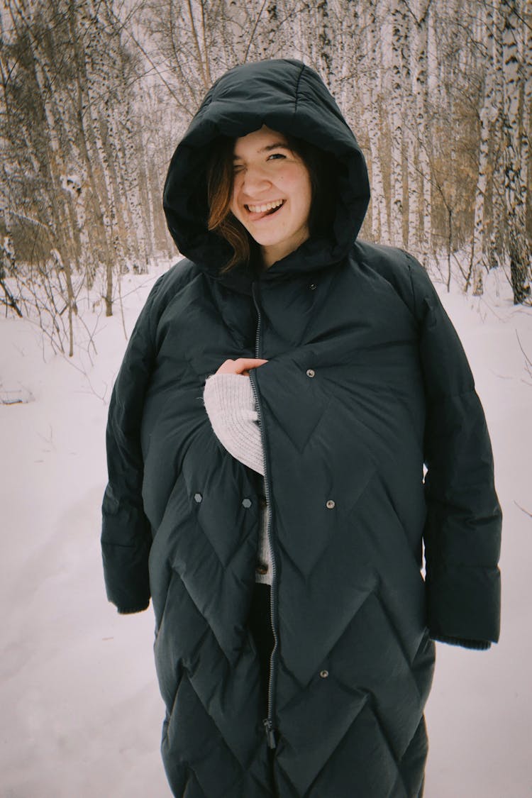 Woman With Her Tongue Out Wearing A Long Puffer Coat 