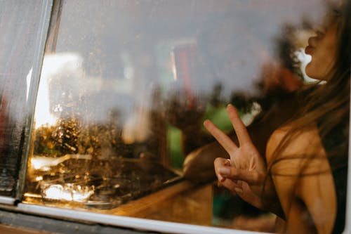 Free Woman Inside a Car Doing a Peace Sign  Stock Photo