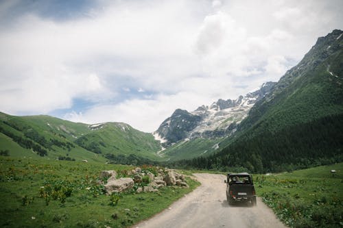 Vehicle Driving on Dirt Road on Mountain Area