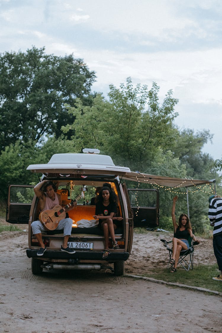 Young Friends Hanging Out At A Camper Van