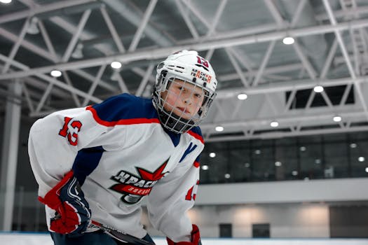 Dynamic shot of a young ice hockey player in full gear on an indoor rink, ready to play.