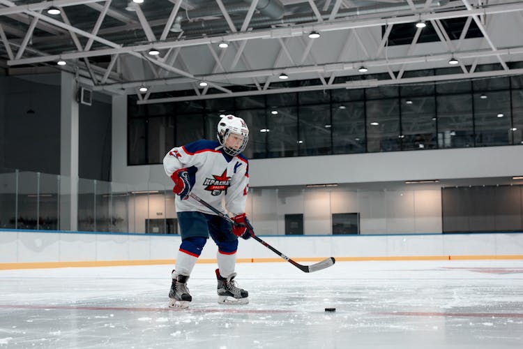 A Person In A White Jersey Playing Ice Hockey