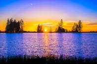 湖畔宁静，日落景色充满活力，绿树成荫