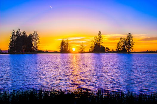 湖畔宁静，日落景色充满活力，绿树成荫