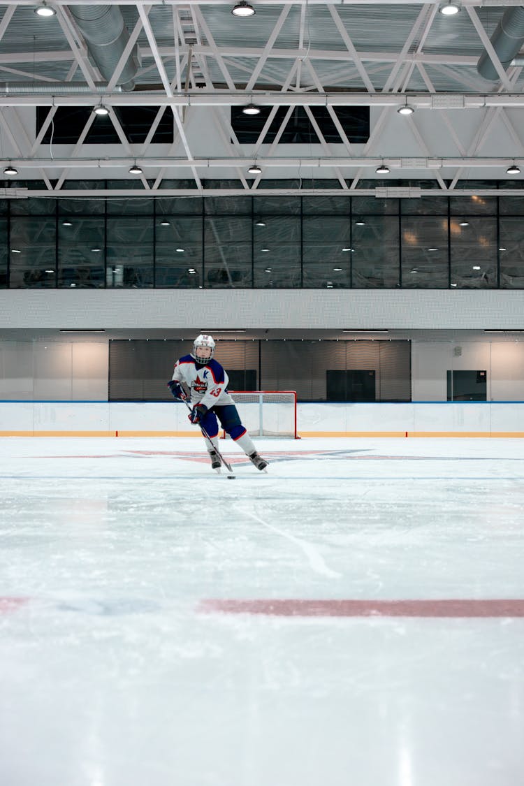 A Hockey Player Skating On Ice Rink