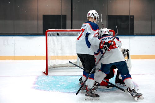 Young Men Playing Ice Hockey In A Rink