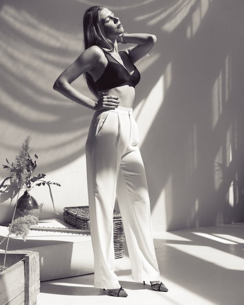 Woman Posing In White Trousers And Black Brassiere