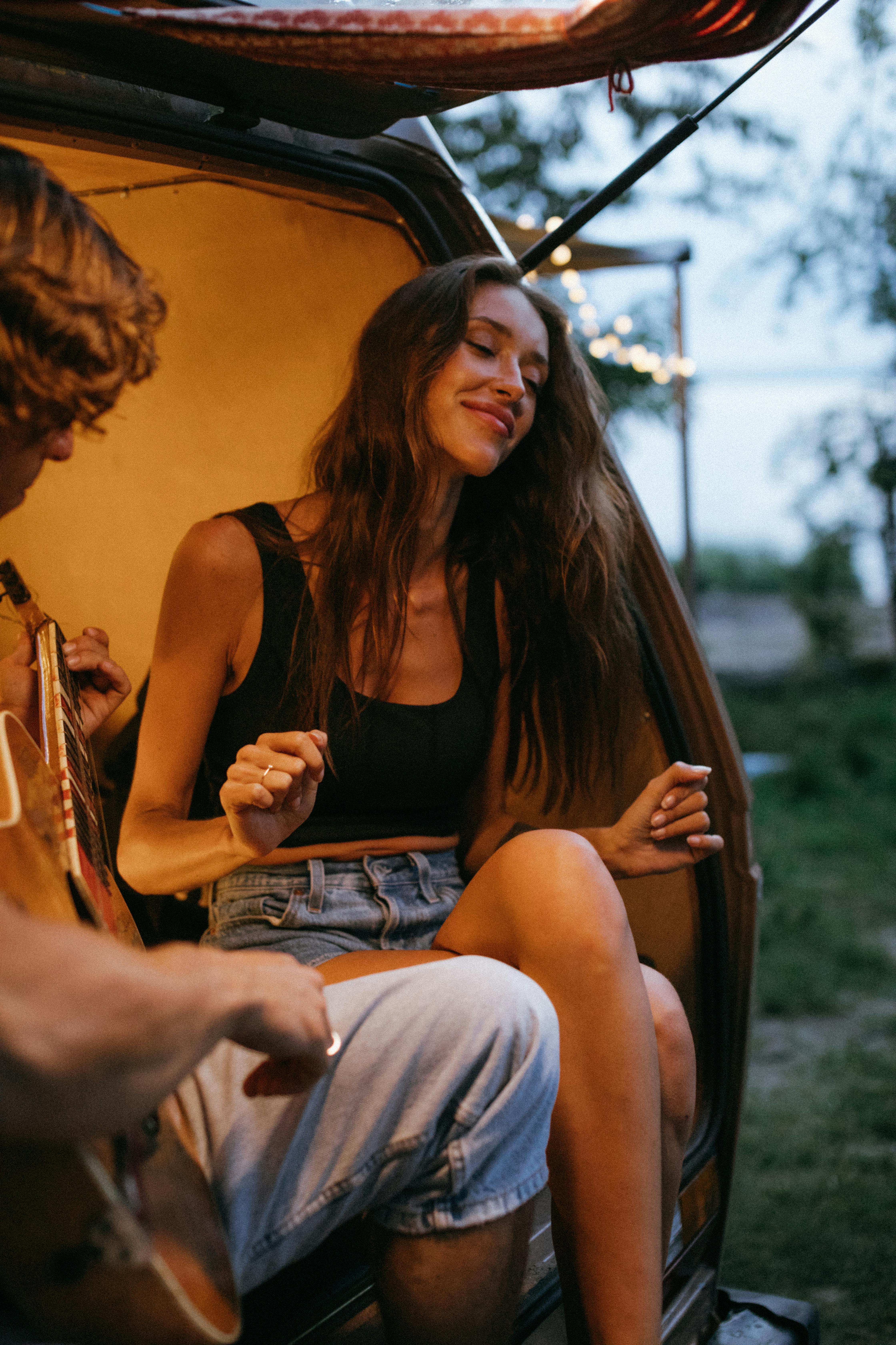 a beautiful woman dancing while her friend plays the guitar