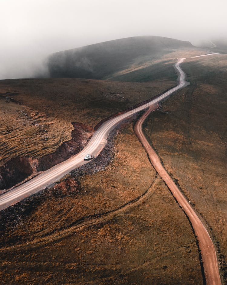 Drone Shot Of A Car Parked On A Mountain Road