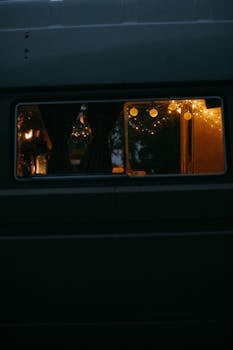 A cozy van interior with warm string lights creating a serene ambiance.