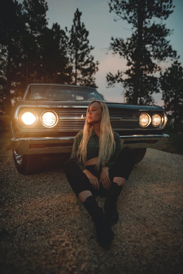 Woman Sitting In Front Of Car