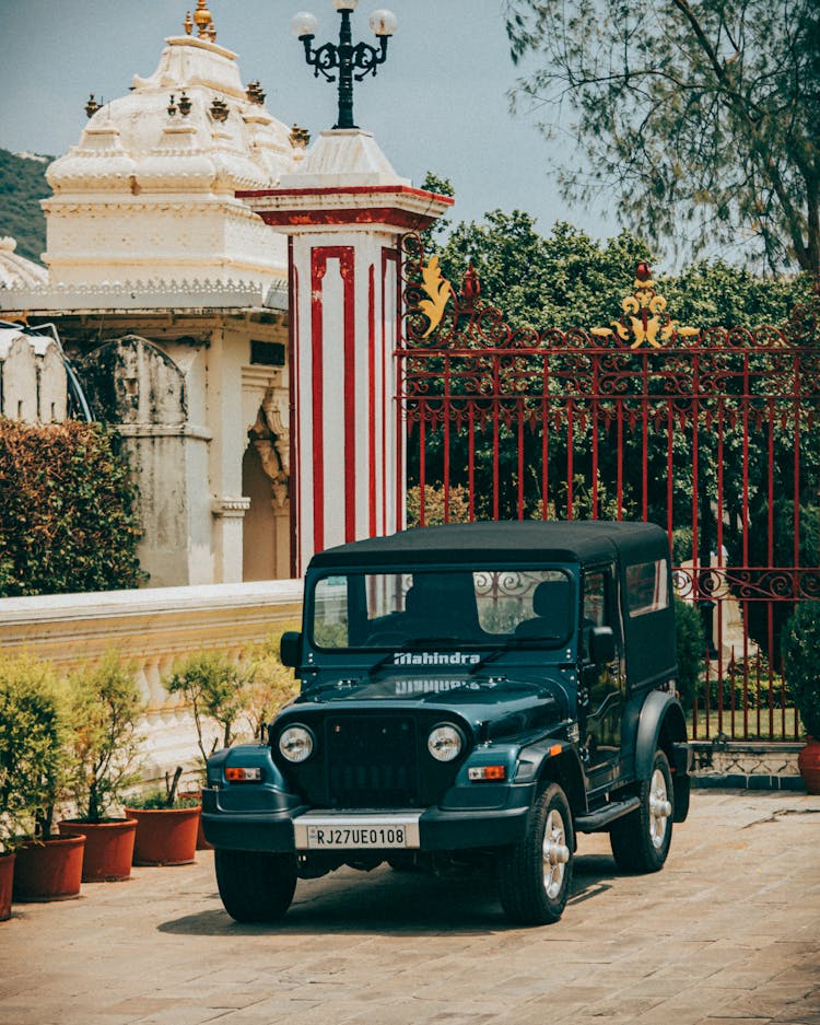 A Mahindra Thar Parked Near A Red Gate