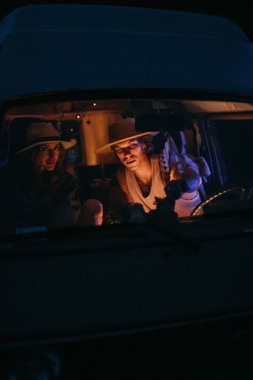 Free Two people enjoying a moody night drive in a vintage car with dim lighting. Stock Photo
