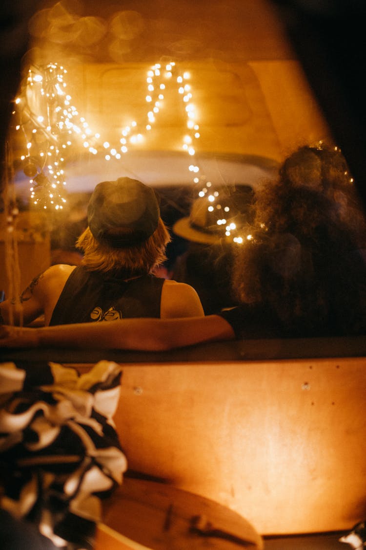 Person Sitting In Room Illuminated By Fairy Lights