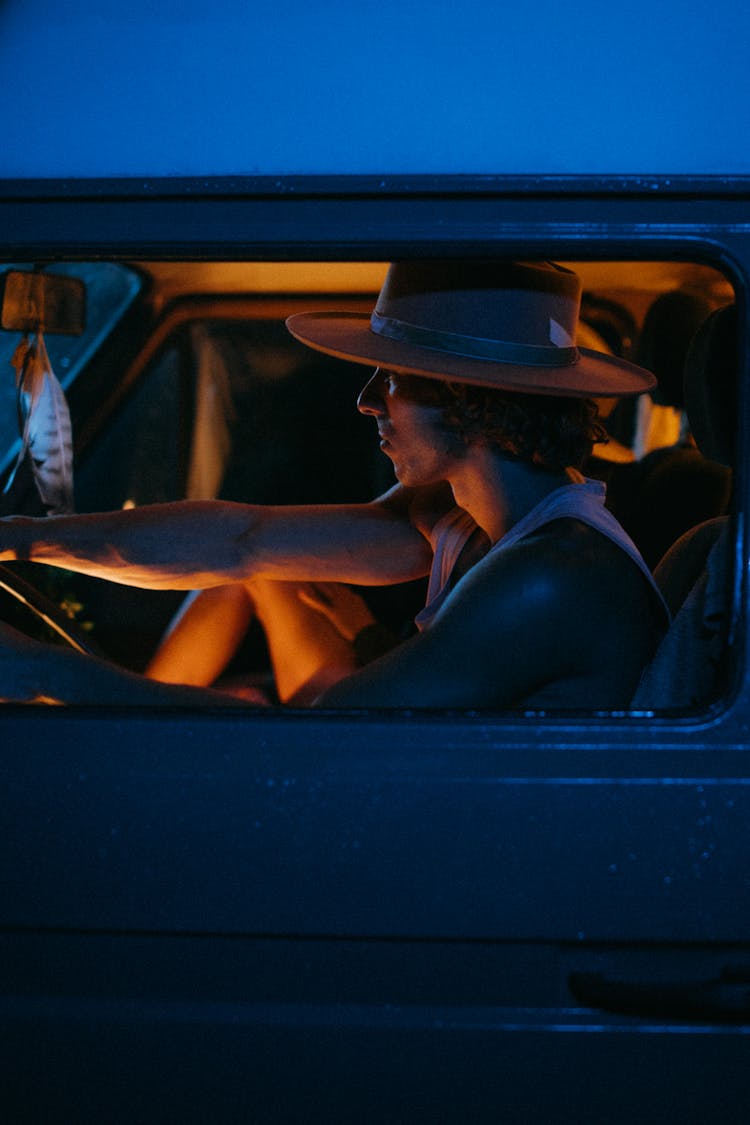 A Man Driving A Car At Night