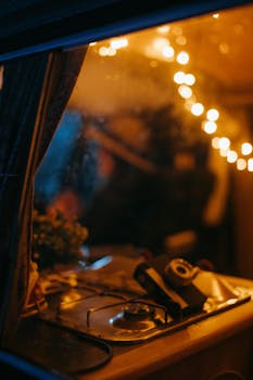 Warm and inviting view inside a camper van featuring a vintage camera and string lights.