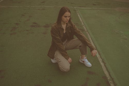 Free Woman in Button Down Shirt Squatting on the Floor Stock Photo