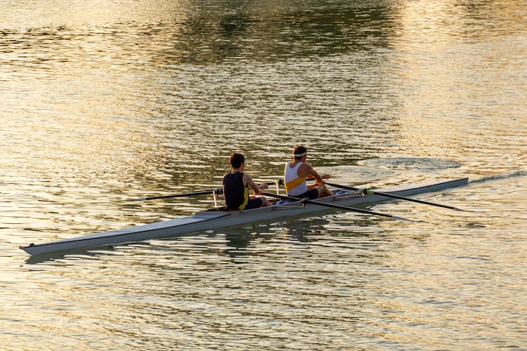 Men Rowing Together On The Lake