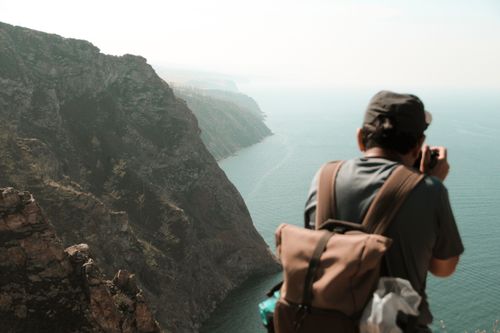 Free A photographer takes shots of the Lake Baikal cliffs in Russia, showcasing breathtaking natural beauty. Stock Photo