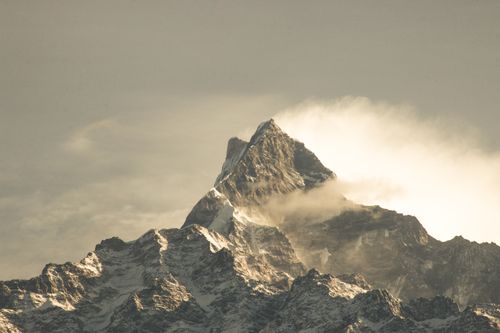 Free A stunning view of a rocky mountain peak shrouded in mist and fog, creating a serene and majestic landscape. Stock Photo