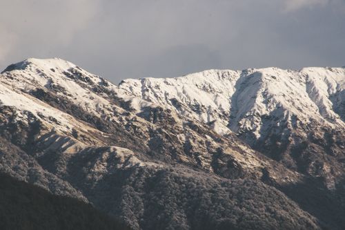 Free Captivating winter mountain range with snow-capped peaks under a cloudy sky, perfect for nature enthusiasts. Stock Photo