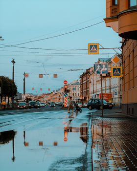 Urban scene with wet city street reflections in Saint Petersburg, Russia.