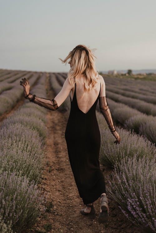 Back View Shot of a Woman in Black Spaghetti Strap Dress Standing on Lavender Field